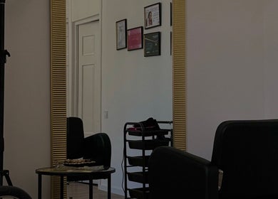 Modern salon interior at Inguna Chaman Hair Design, Rīga, LV, featuring chic seating and decor.