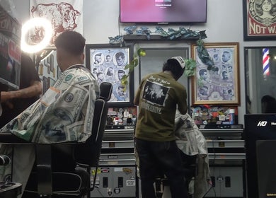 Client receiving a stylish haircut at Haircut by Ronii_moo, Bali, Bali, ID. Vibrant barber shop interior.