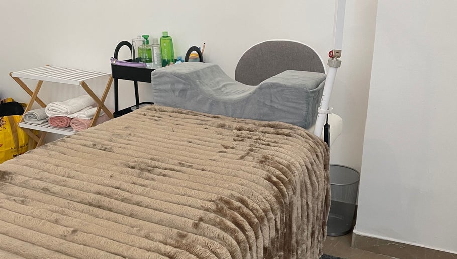Luxurious massage bed at Glow By Miriam, Bragança, Bragança, PT, featuring plush blanket and towels.