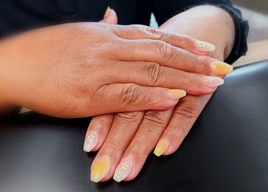 Stylish daisy nail art at Cute-Icles, Boksburg, Gauteng, ZA, showcasing detailed manicure on hands.
