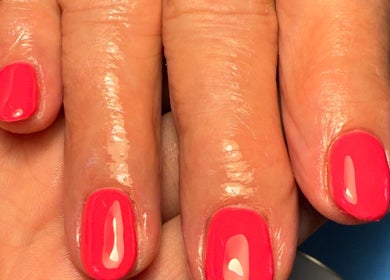 Vibrant coral nails at Daisie Mae Beauty, Lechlade, England, GB showcasing expert manicure.