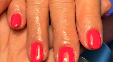 Vibrant coral nails at Daisie Mae Beauty, Lechlade, England, GB showcasing expert manicure.