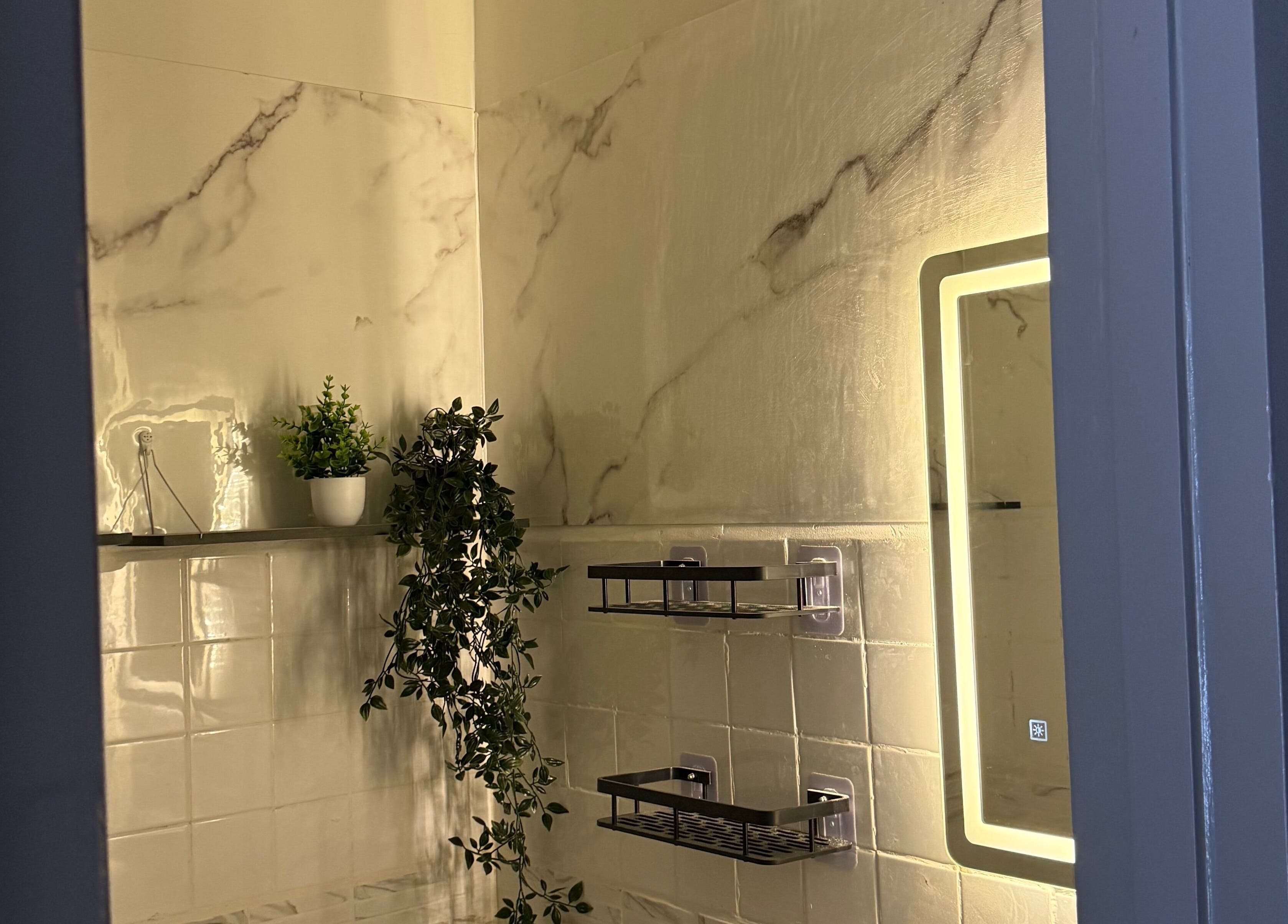 Luxurious bathroom at Relash Eyelash Studio, Quezon City, Metro Manila, PH with marble tiles and plants.