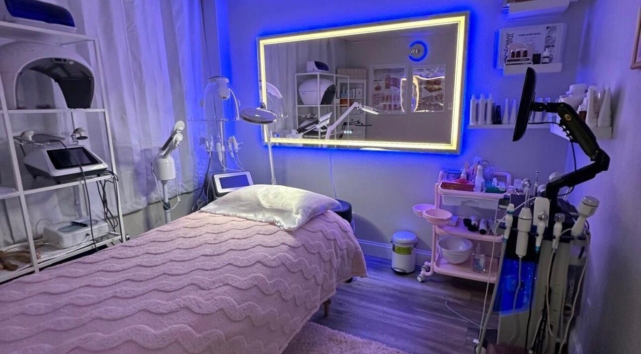 Relaxing spa room at Majestic Beauty Art, Winter Park, Florida, US with glowing mirror and cozy bed.