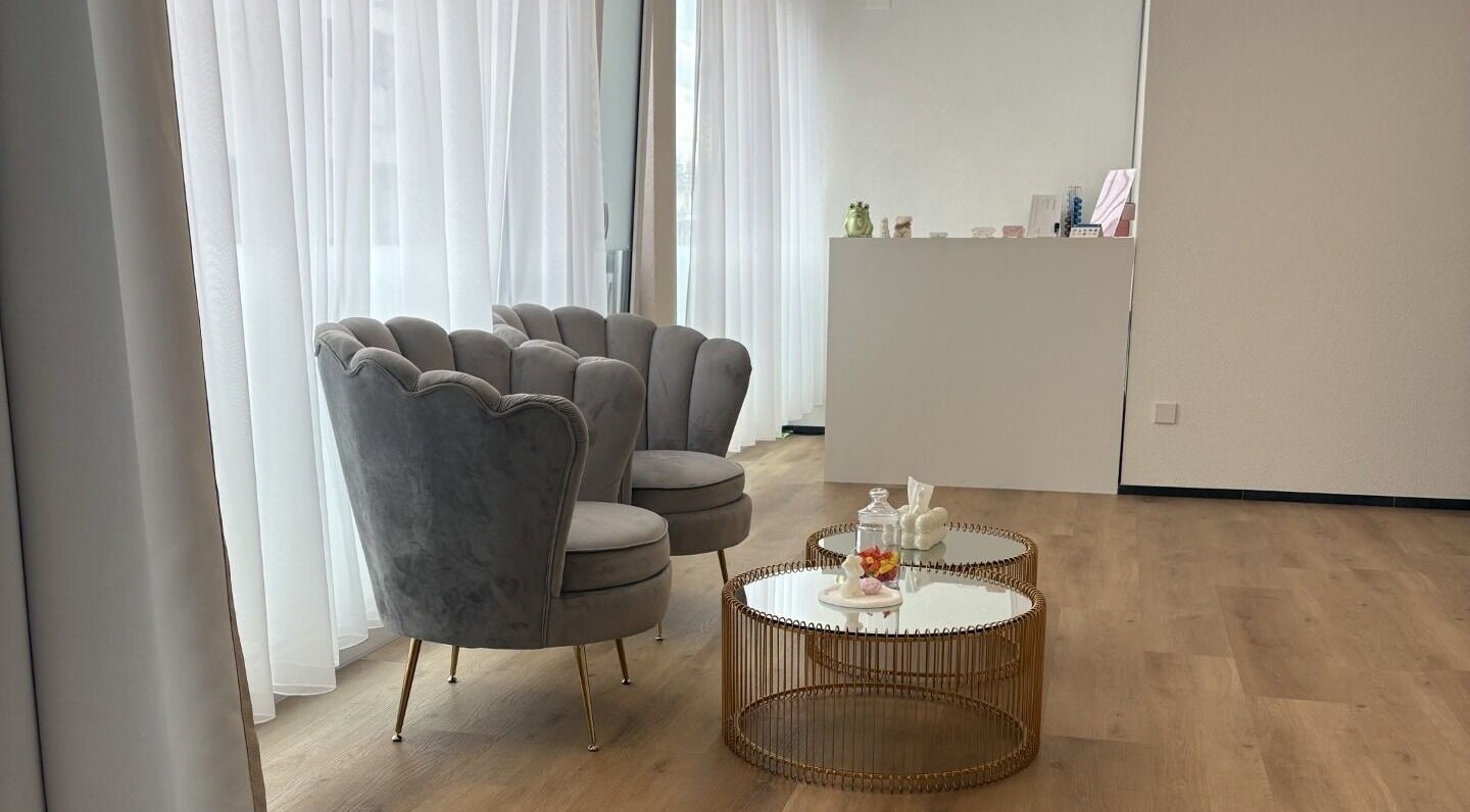 Elegante Wartebereich bei SHAN Laser & Skin in Widnau, Sankt Gallen, CH, mit grauen Sesseln und modernem Tisch.