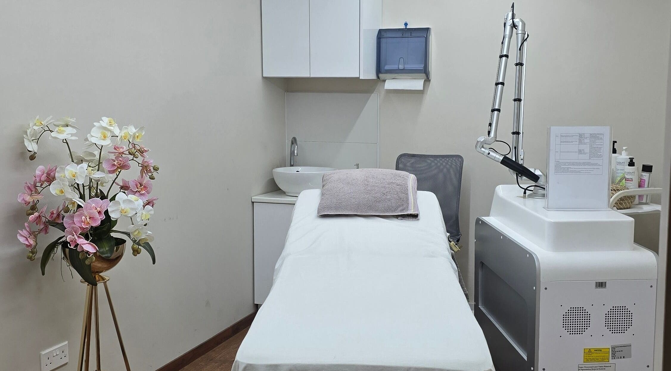 Άνετο δωμάτιο θεραπείας στο Mandarinlaser_aesthetics στη Λεμεσό, Λεμεσός, CY με λουλούδια και εξοπλισμό.