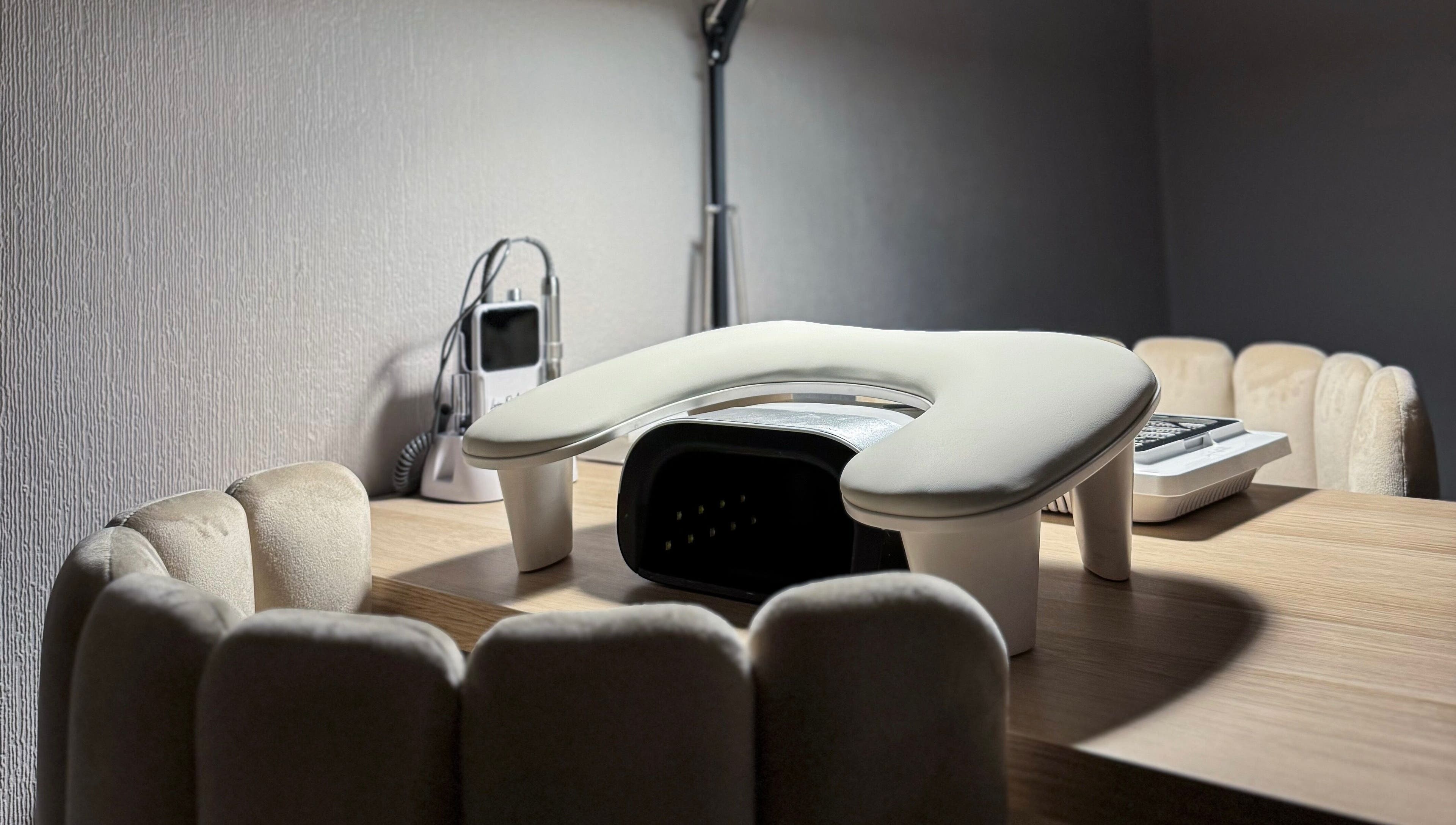 Cozy manicure station at Pretty Little Nails, Reigate, England, GB with plush chairs and nail equipment.