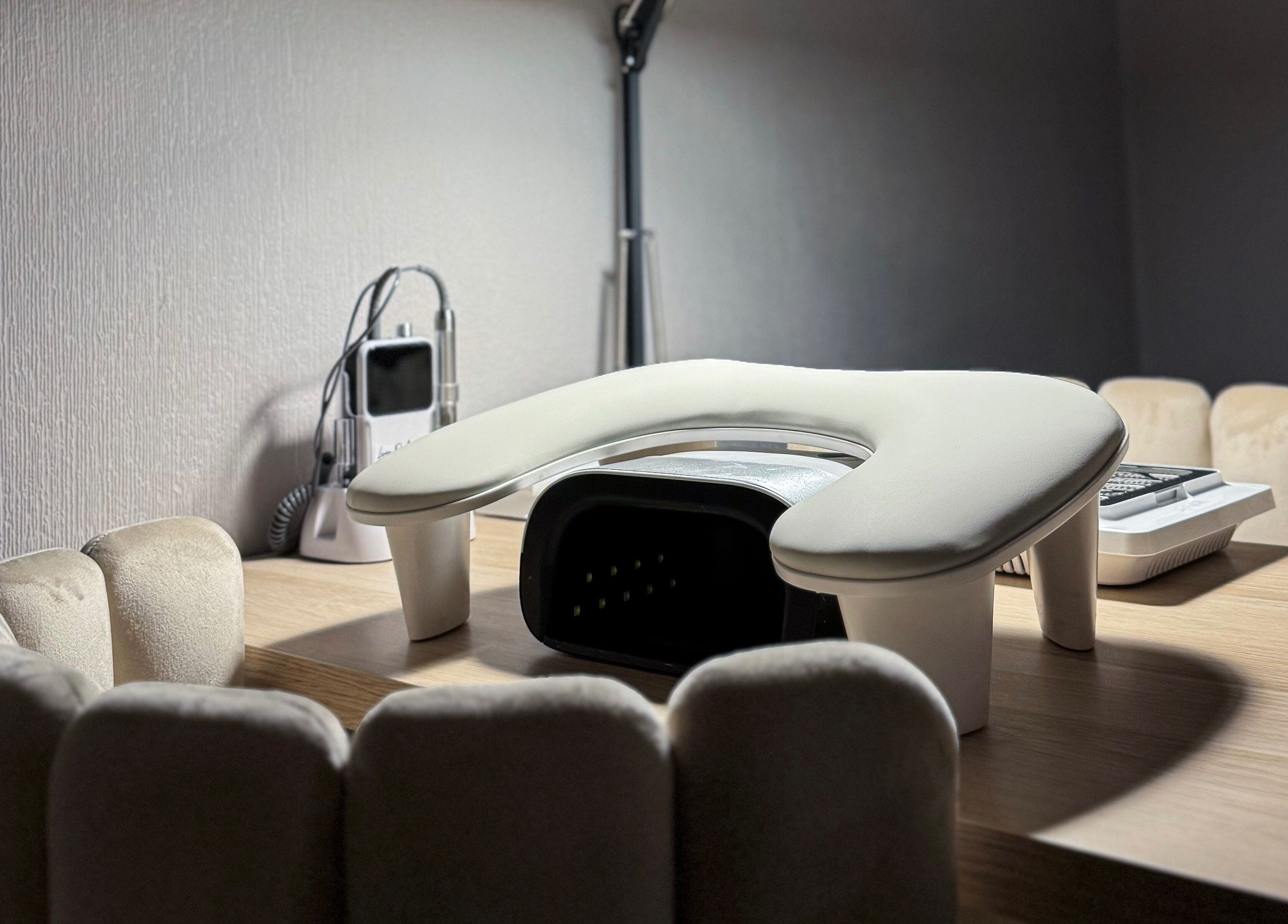 Cozy manicure station at Pretty Little Nails, Reigate, England, GB with plush chairs and nail equipment.