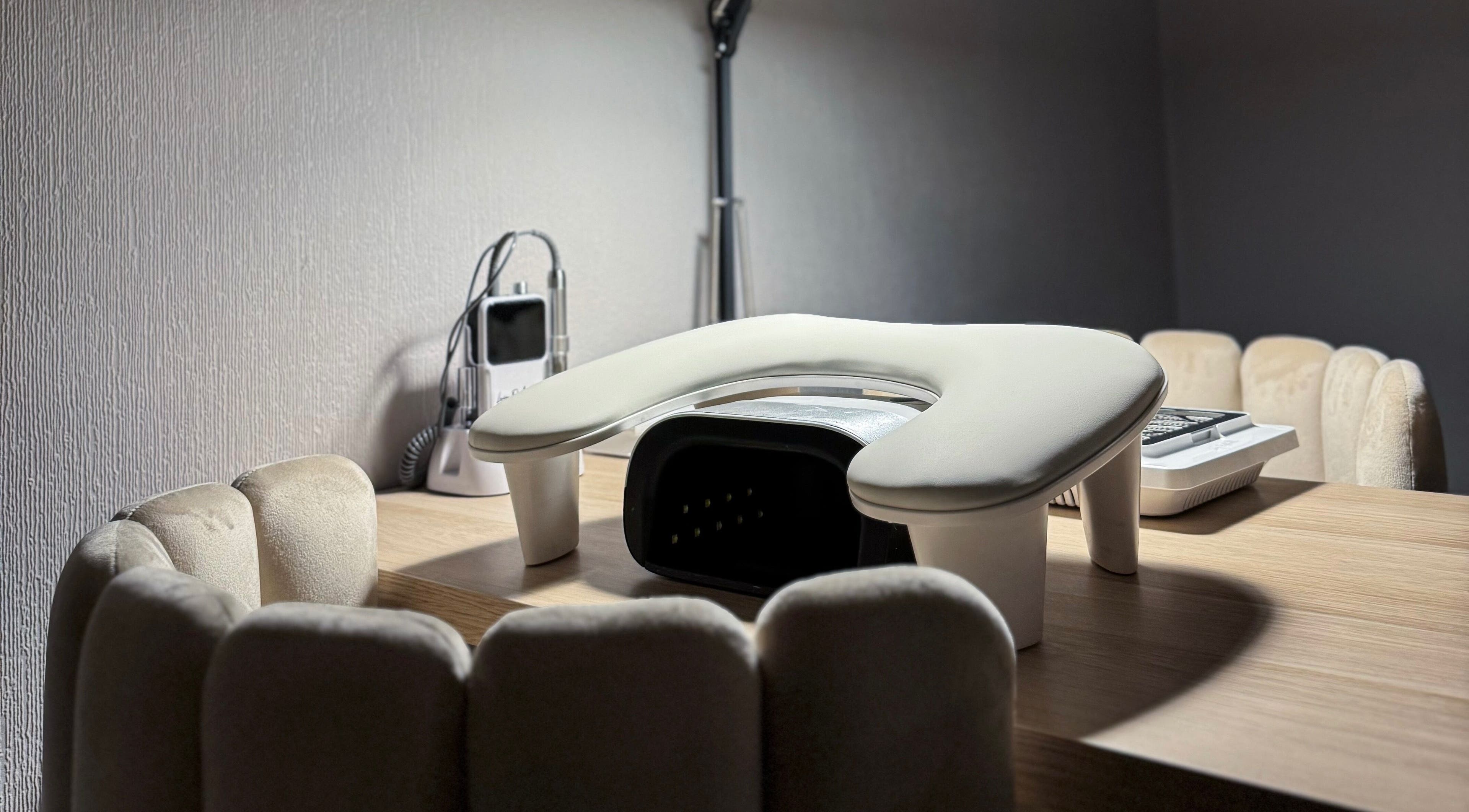 Cozy manicure station at Pretty Little Nails, Reigate, England, GB with plush chairs and nail equipment.