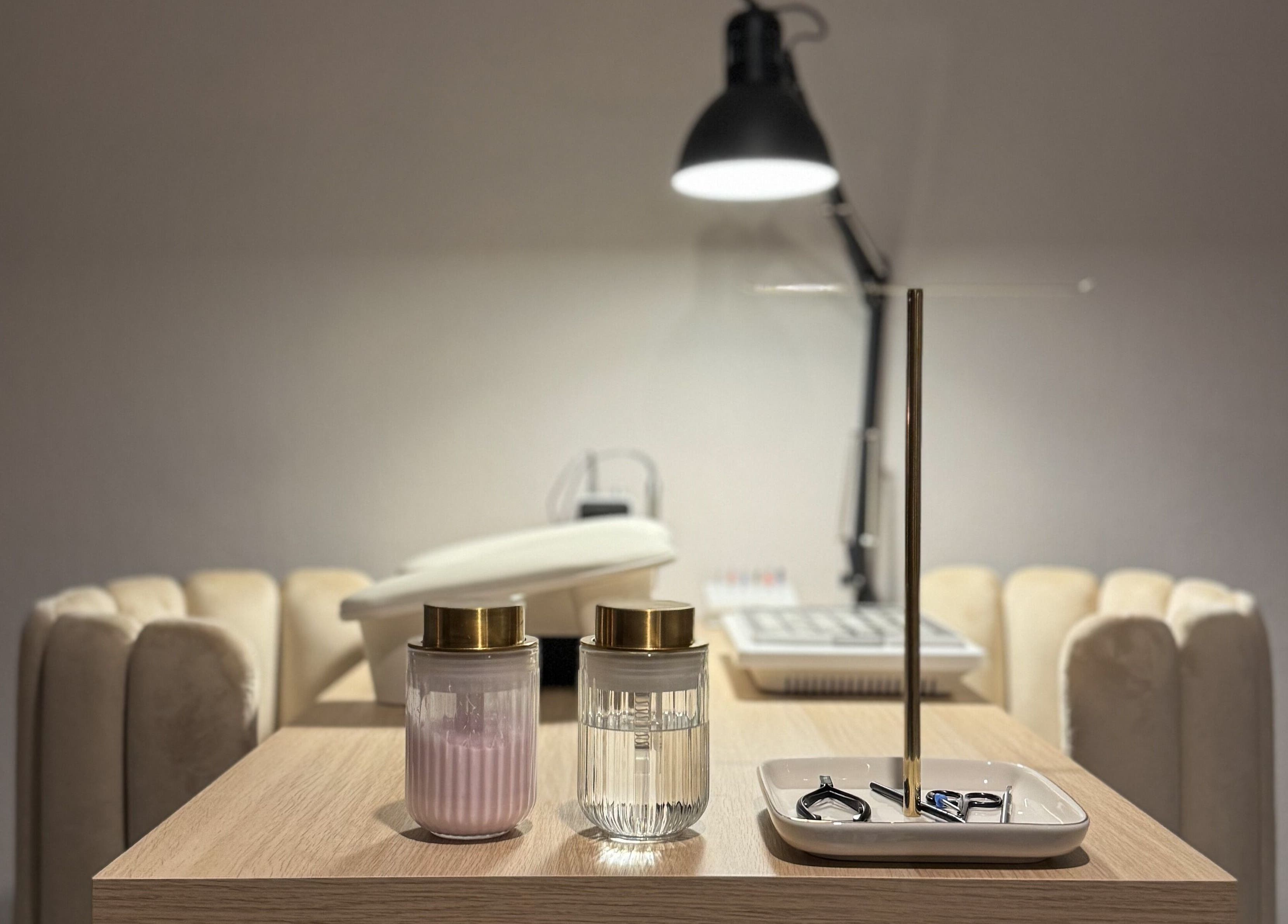 A modern nail salon setup at Pretty Little Nails, Reigate, England, GB featuring plush seating and tools.