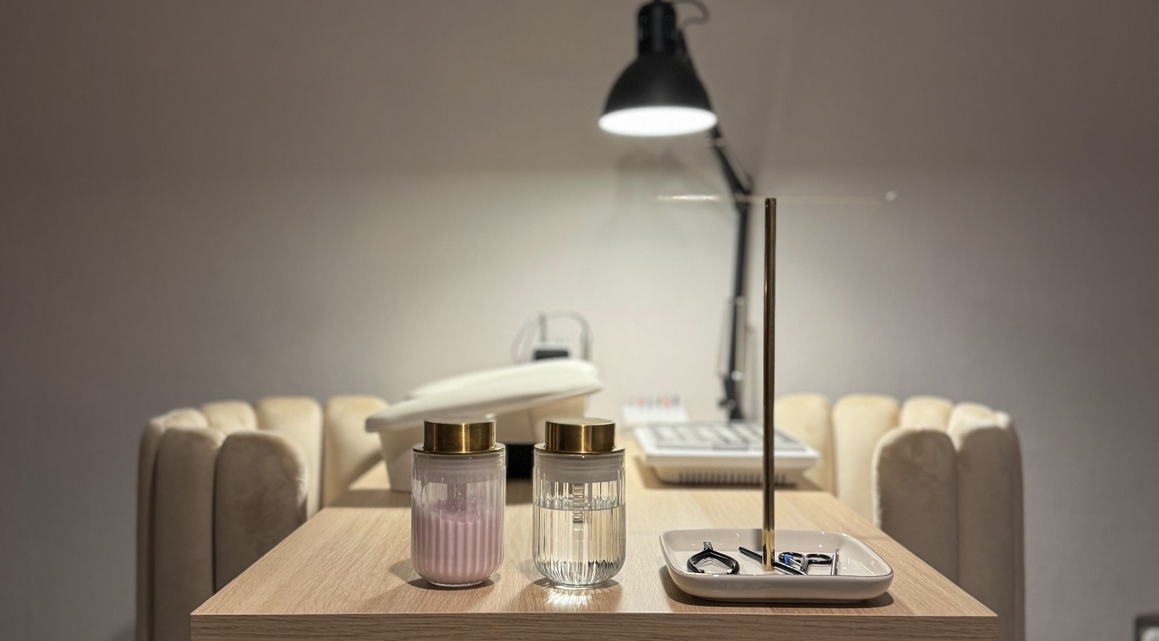 A modern nail salon setup at Pretty Little Nails, Reigate, England, GB featuring plush seating and tools.