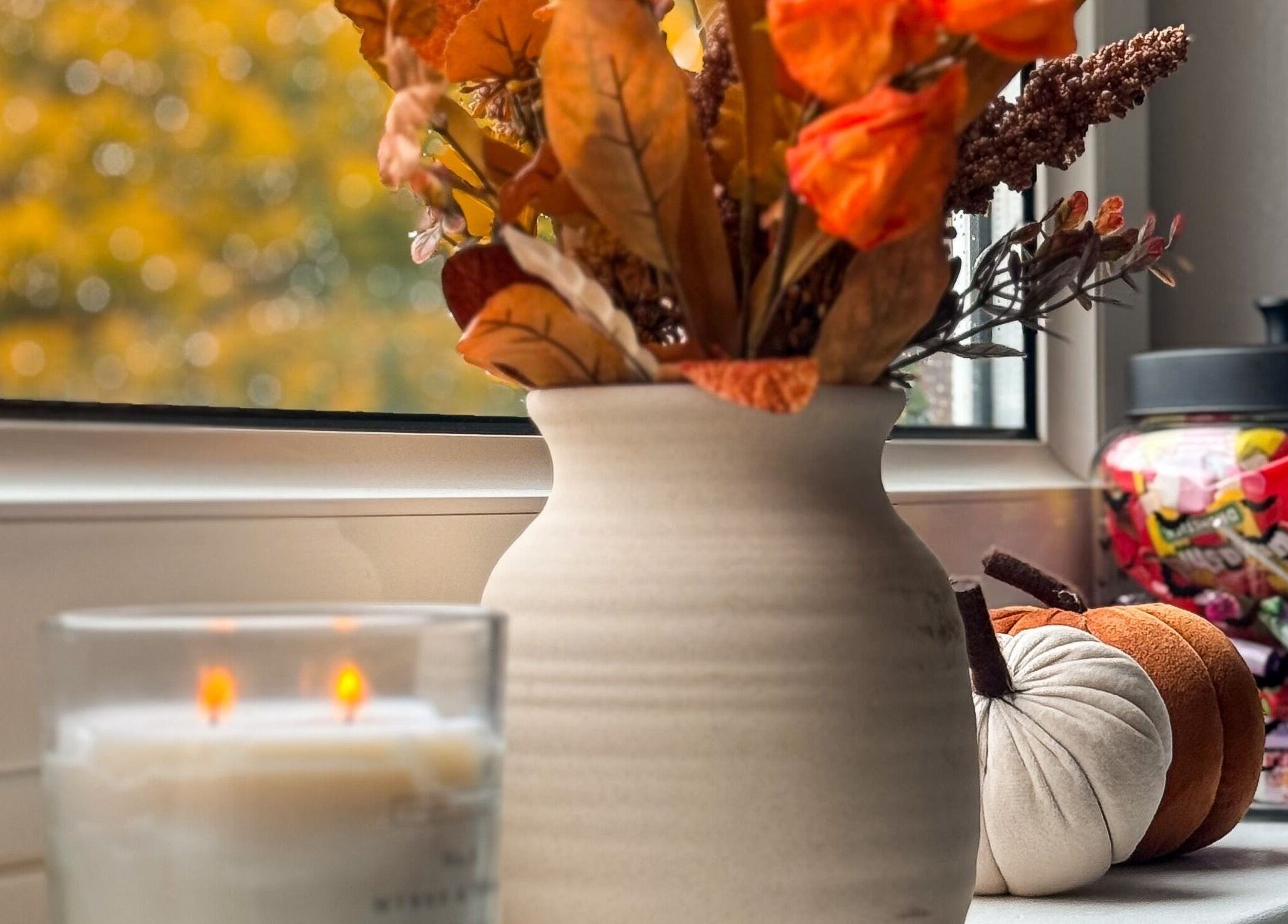 Autumn decor at Pretty Little Nails, Reigate, England, GB, featuring a vase, candle, and candies.