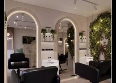 Interior moderno de Griseidabeauty_salon en Londres, Inglaterra, GB, con sillas negras y espejos iluminados.