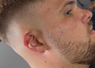 Modern hairstyle at Beau Brims, Copthorne, England, GB showcasing a clean fade cut.