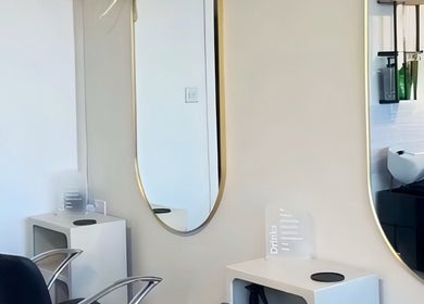 Elegant salon station at HairByMadi, Bradford, England, GB showcasing modern styling chairs and mirrors.