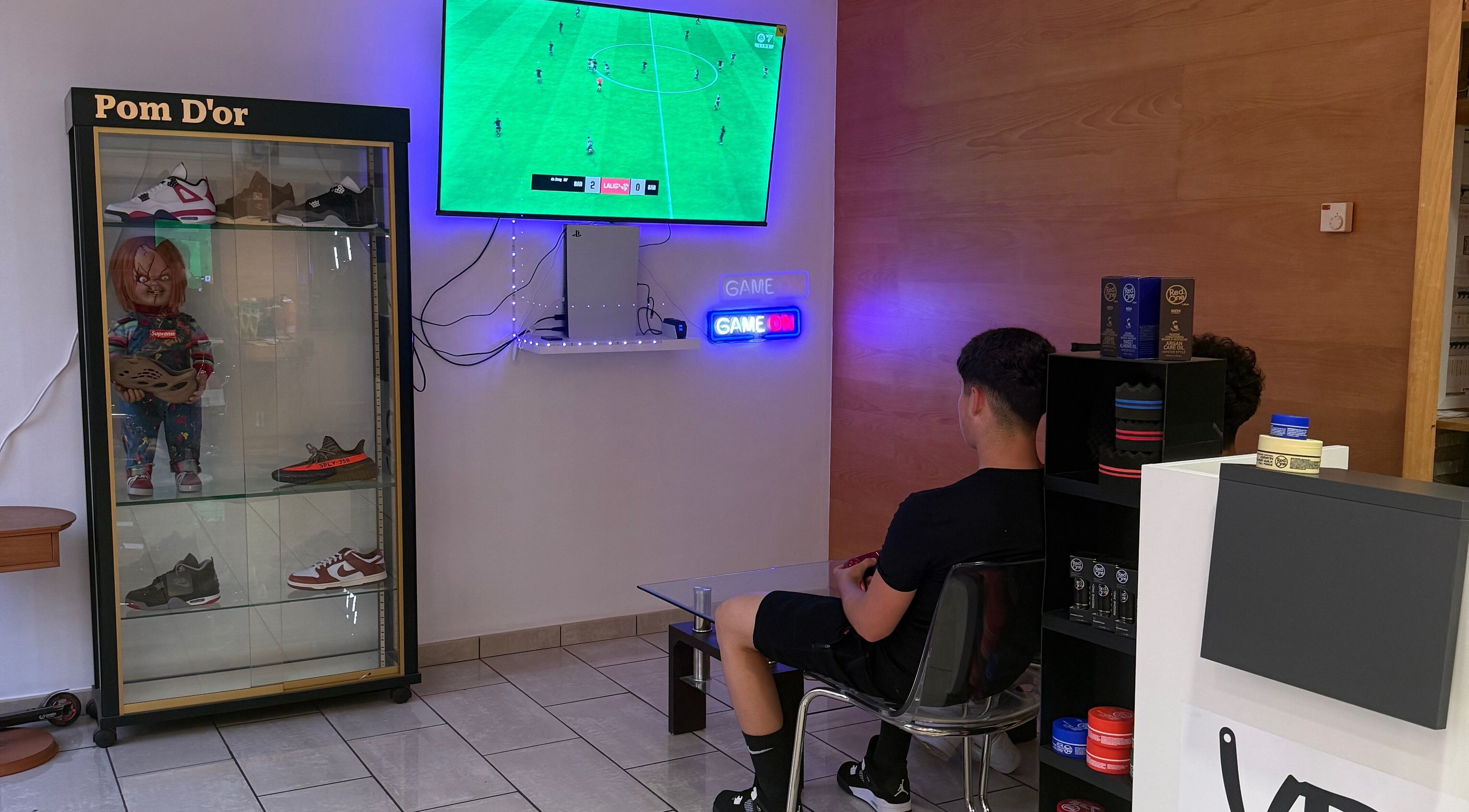 Cliente viendo TV en Vramens Barber Shop, Agurain / Salvatierra, Euskadi, ES con decoración moderna.