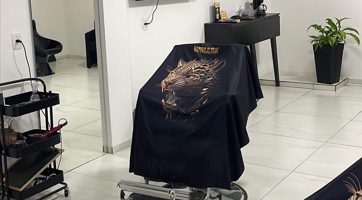 Interior moderno do LurczBarber em Rio Grande Do Sul, elegante cadeira de barbeiro com capa decorativa.