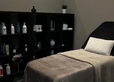 Cmj Health Care & Beauty treatment room in Bruxelles, with massage table and product shelves.