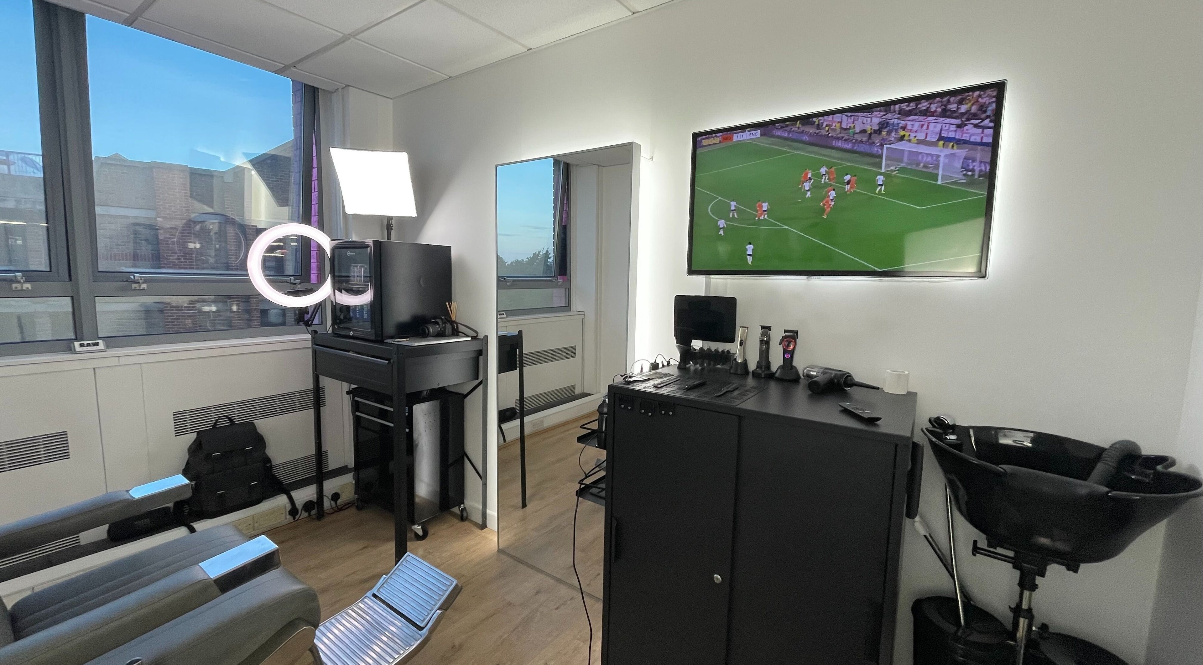 Modern salon interior at RAW CUTS, Barking, England, GB with styling stations and cozy lighting.