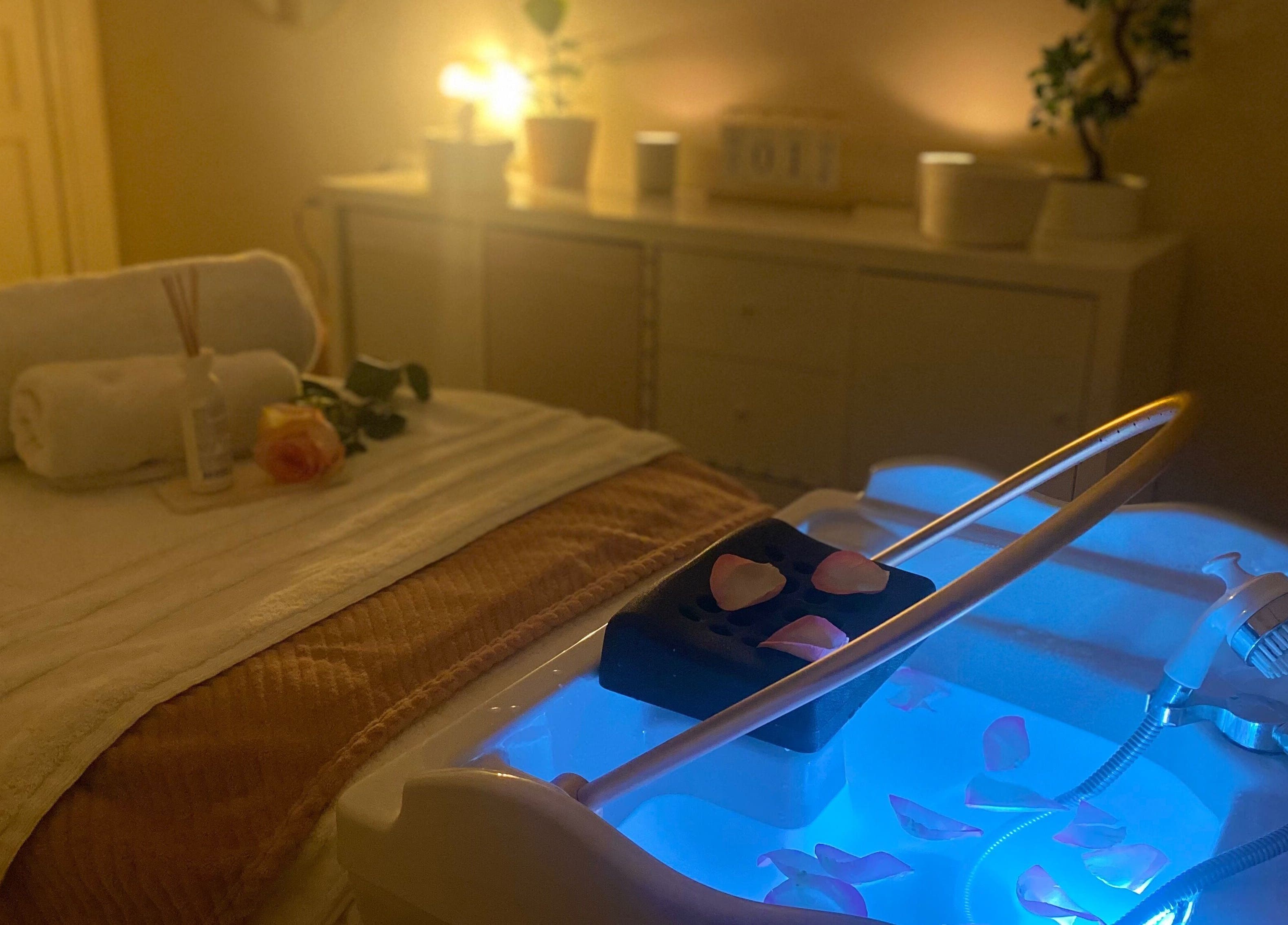 Table de massage relaxante à Headspa By M, Ozoir-la-ferrière, Île-de-France, FR, avec lumière apaisante et pétales.