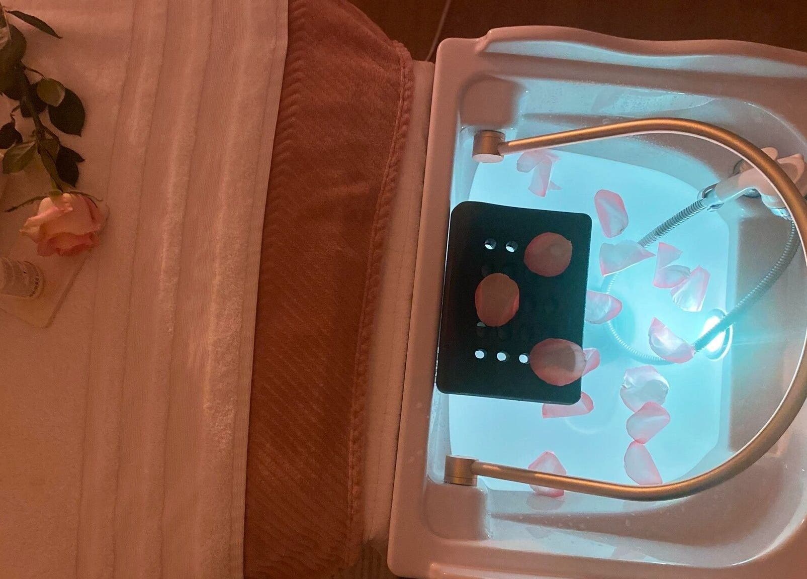 Table de soin avec serviettes et pétales chez Headspa By M à Ozoir-la-Ferrière, Île-de-France, FR.