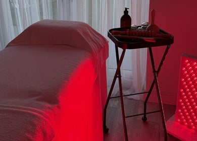 Red light therapy room at Sculpt & Reset by H, Broxbourne, England, GB, featuring massage table and equipment.