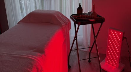 Red light therapy room at Sculpt & Reset by H, Broxbourne, England, GB, featuring massage table and equipment.
