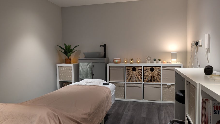 Tranquil spa room at Axiom Nature, London, England, GB with cozy lighting and a massage table.