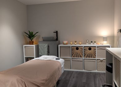 Tranquil spa room at Axiom Nature, London, England, GB with cozy lighting and a massage table.
