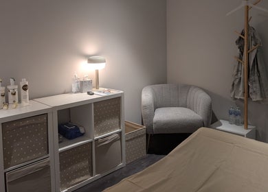 Calm treatment room at Axiom Nature, London, England, GB displaying a cozy chair and skincare supplies.