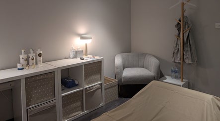 Calm treatment room at Axiom Nature, London, England, GB displaying a cozy chair and skincare supplies.