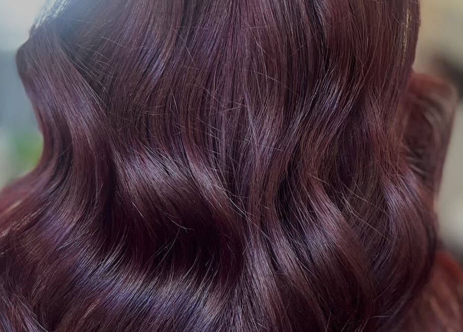 Elegant wavy hairstyle with rich burgundy tones at Hair by Gillian Edmonstone, Banchory, Scotland, GB.