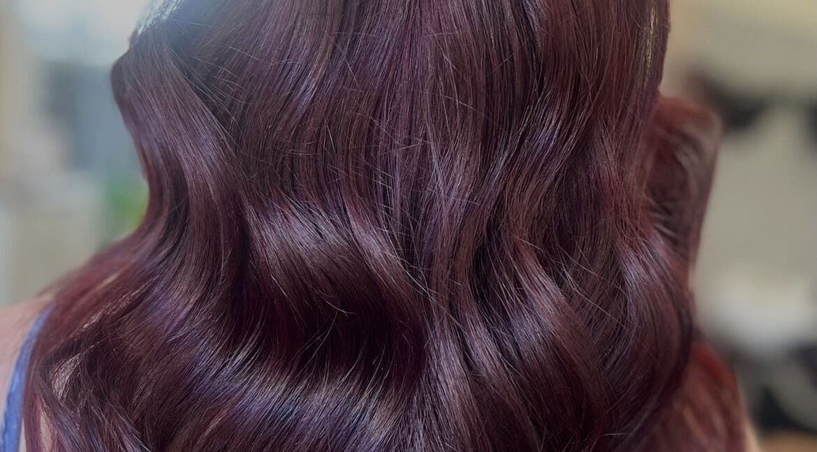 Elegant wavy hairstyle with rich burgundy tones at Hair by Gillian Edmonstone, Banchory, Scotland, GB.