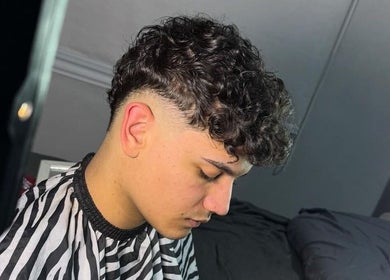 Stylish curly fade haircut at Delpa Barber in Arroyo Seco, Santa Fe, AR.