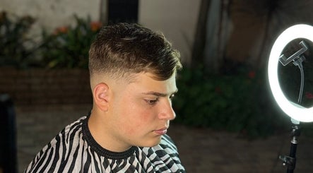 Side profile of a young man with a fresh fade haircut at Delpa Barber, Arroyo Seco, Santa Fe, AR, under soft light.