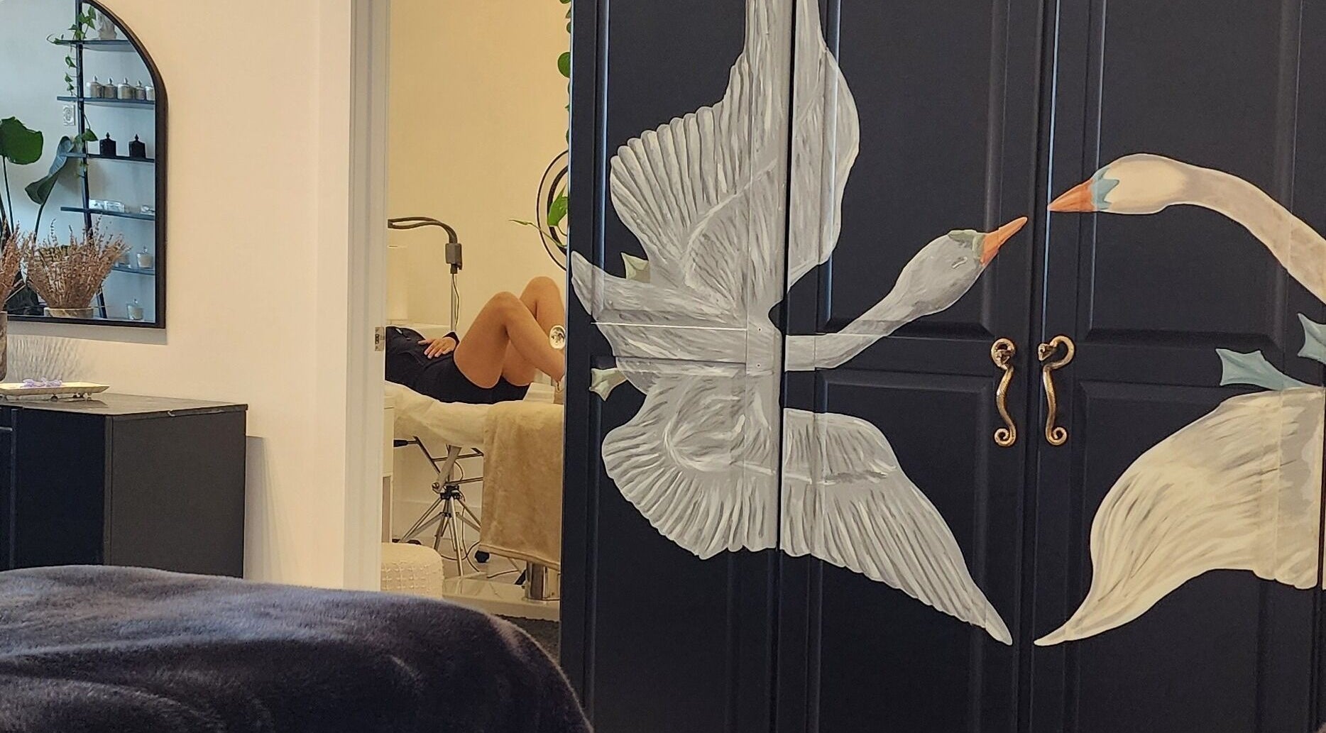 Serene wellness space at Lashes by Alexa in Miami, Florida, US featuring elegant swan mural and cozy treatment area.