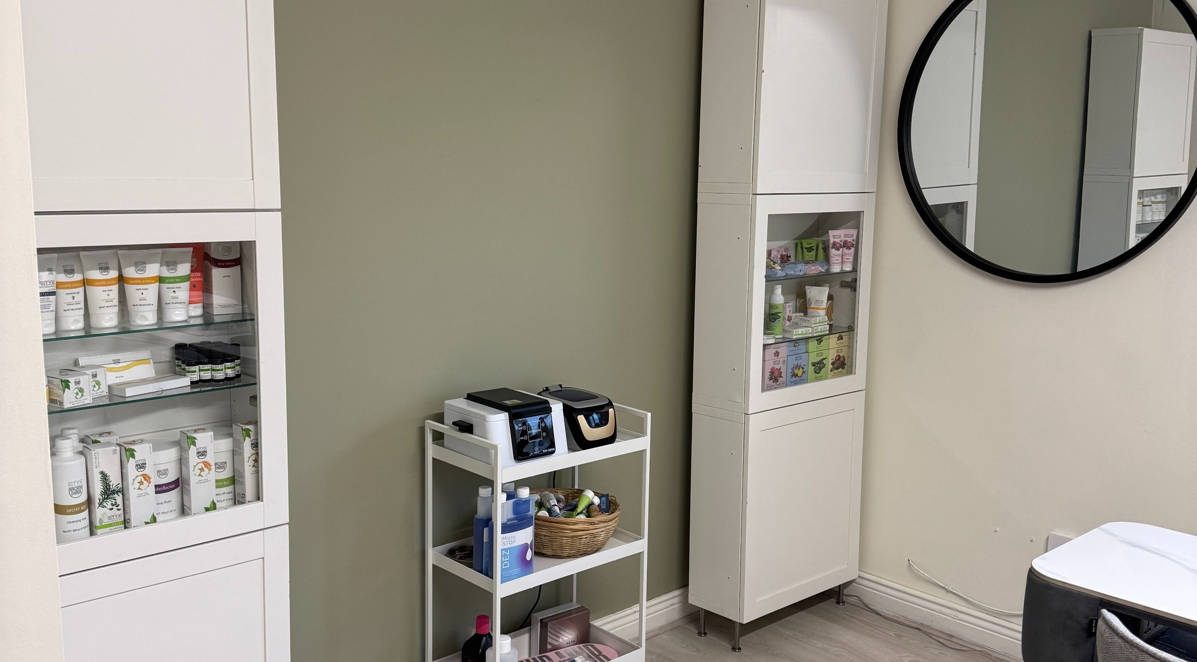 Product shelves and a round mirror at Solais Beauty Studio, Ratoath, IE, displaying skincare and wellness items.