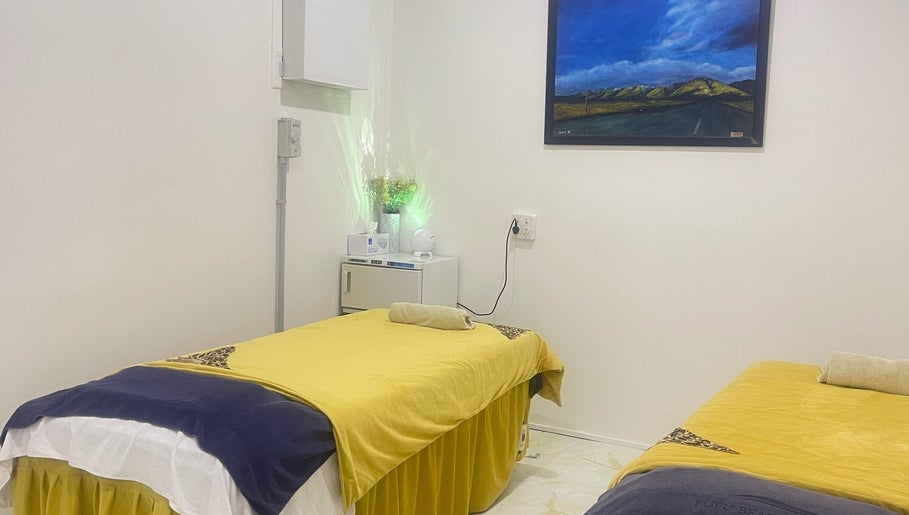 Fufu Beauty Salon的宁静按摩室，位于Auckland, NZ，配有舒适的黄色床铺。