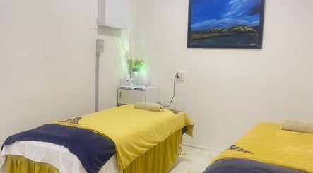 Fufu Beauty Salon的宁静按摩室，位于Auckland, NZ，配有舒适的黄色床铺。
