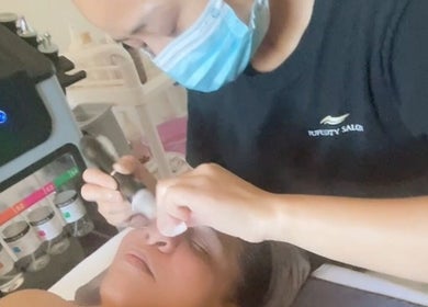 Fufu Beauty Salon的美容师在奥克兰，NZ给顾客做面部护理。