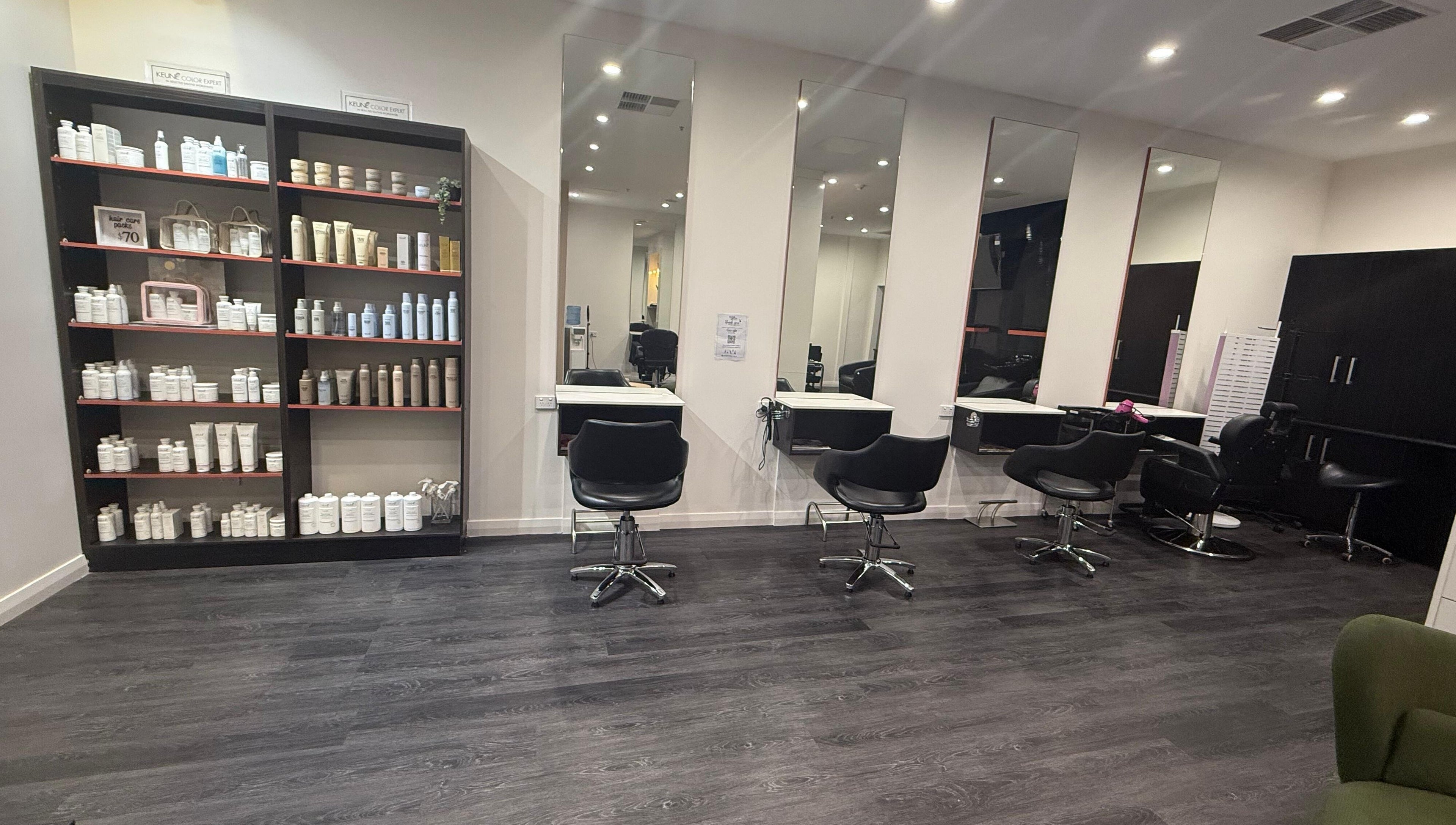 Chic salon interior at Glam up and Glow in Gilles Plains, South Australia, AU with styling stations and product shelves.