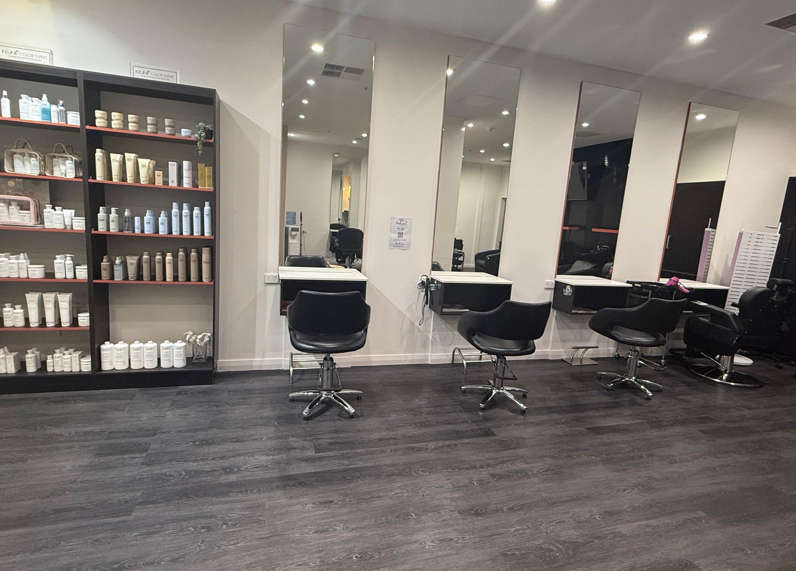 Chic salon interior at Glam up and Glow in Gilles Plains, South Australia, AU with styling stations and product shelves.