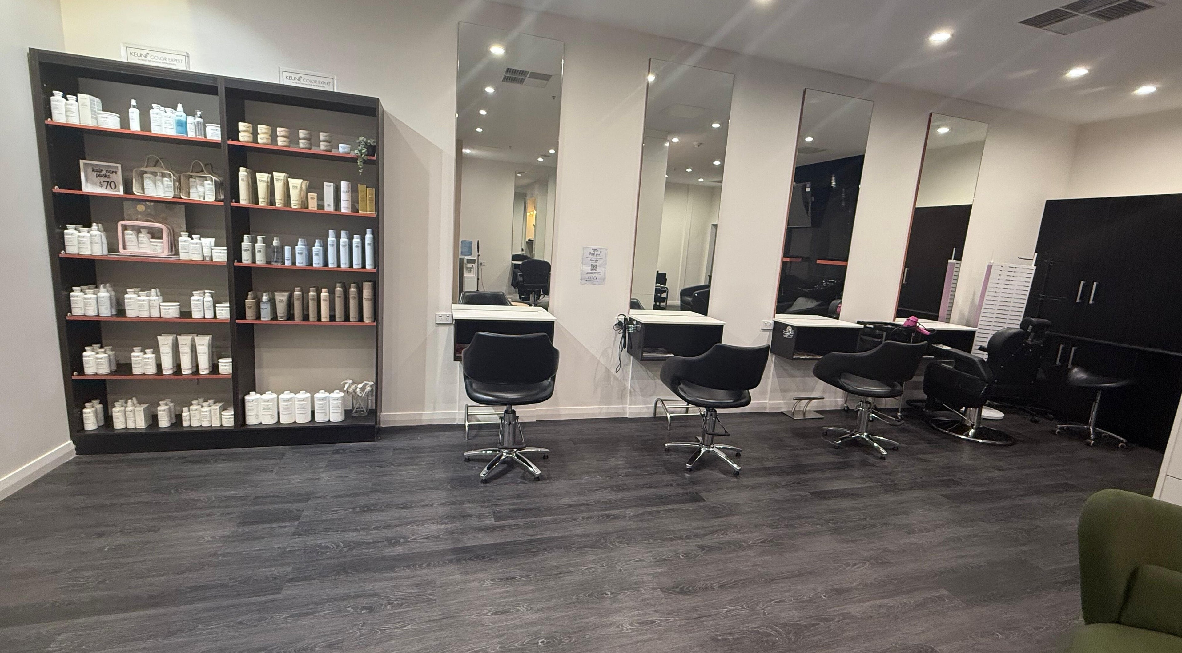 Chic salon interior at Glam up and Glow in Gilles Plains, South Australia, AU with styling stations and product shelves.