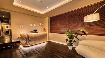 Sleek reception area at Therapy by Aq in Birmingham, England, GB featuring modern decor and ambient lighting.