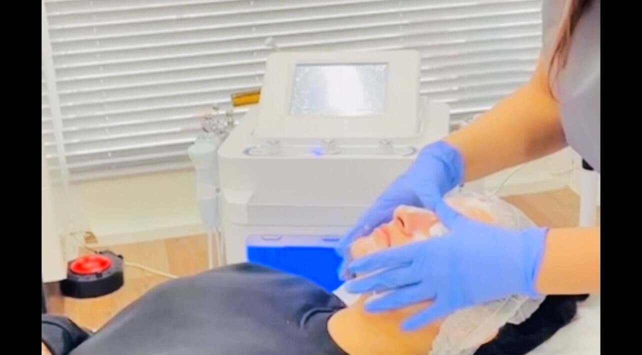 Facial treatment at MGB Aesthetic Clinic, Greater, England, GB, showing a serene client receiving expert care.