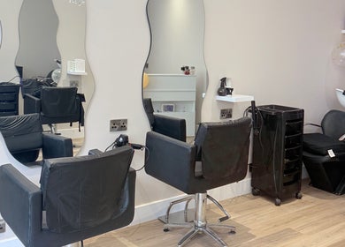 Chic salon interior at Dream Hair, Huntingdon, England, GB with modern styling stations and mirrors.
