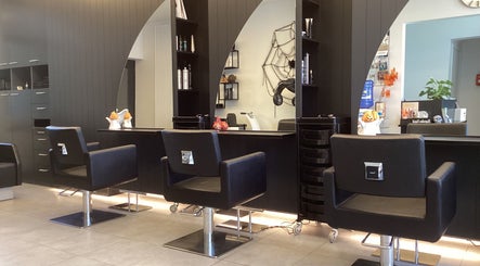 Interieur van Kapsalon Sigrid in Waregem, Vlaanderen, BE met moderne kappersstoelen en strakke inrichting.