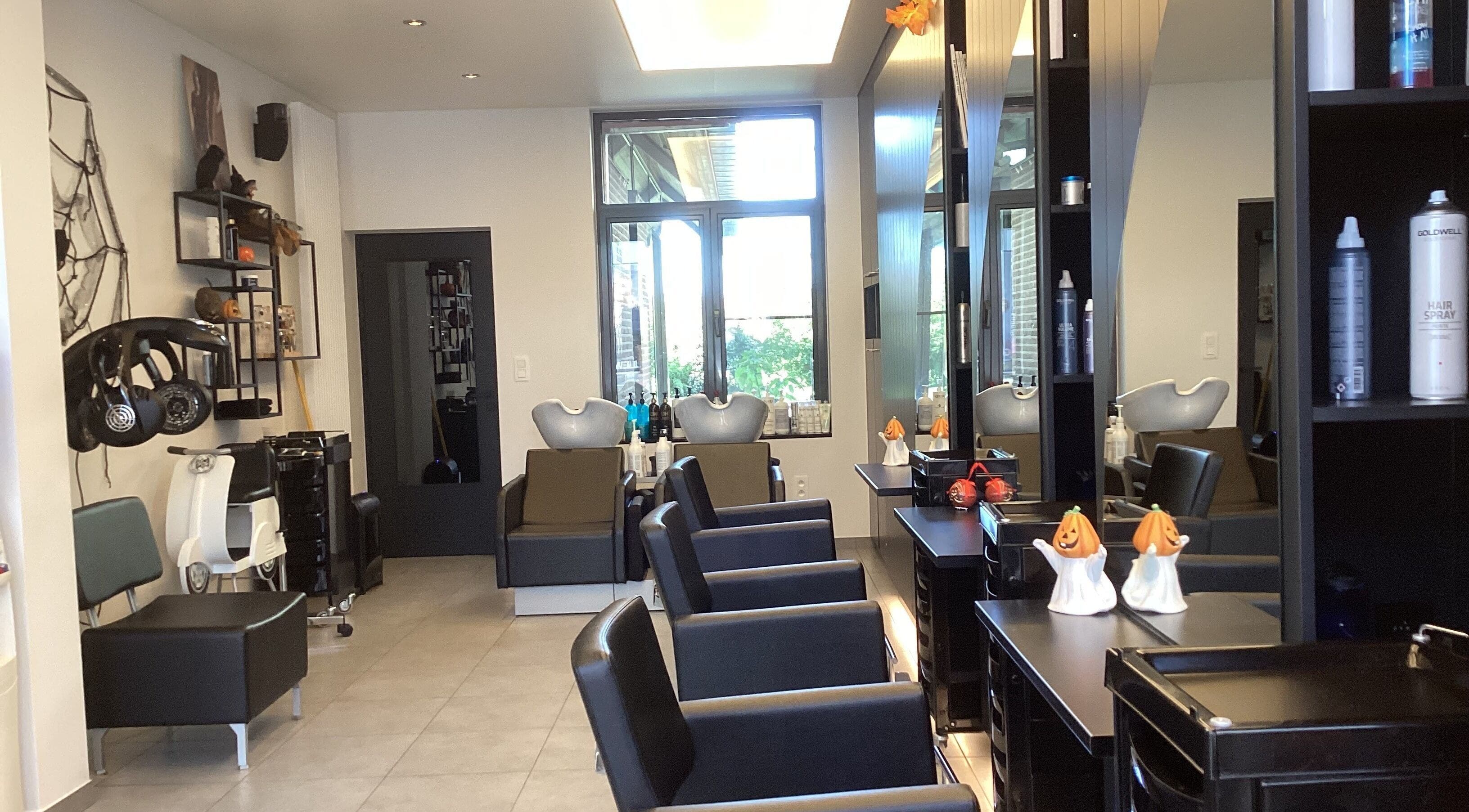 Interieur van Kapsalon Sigrid in Waregem, Vlaanderen, BE met moderne stoelopstelling.