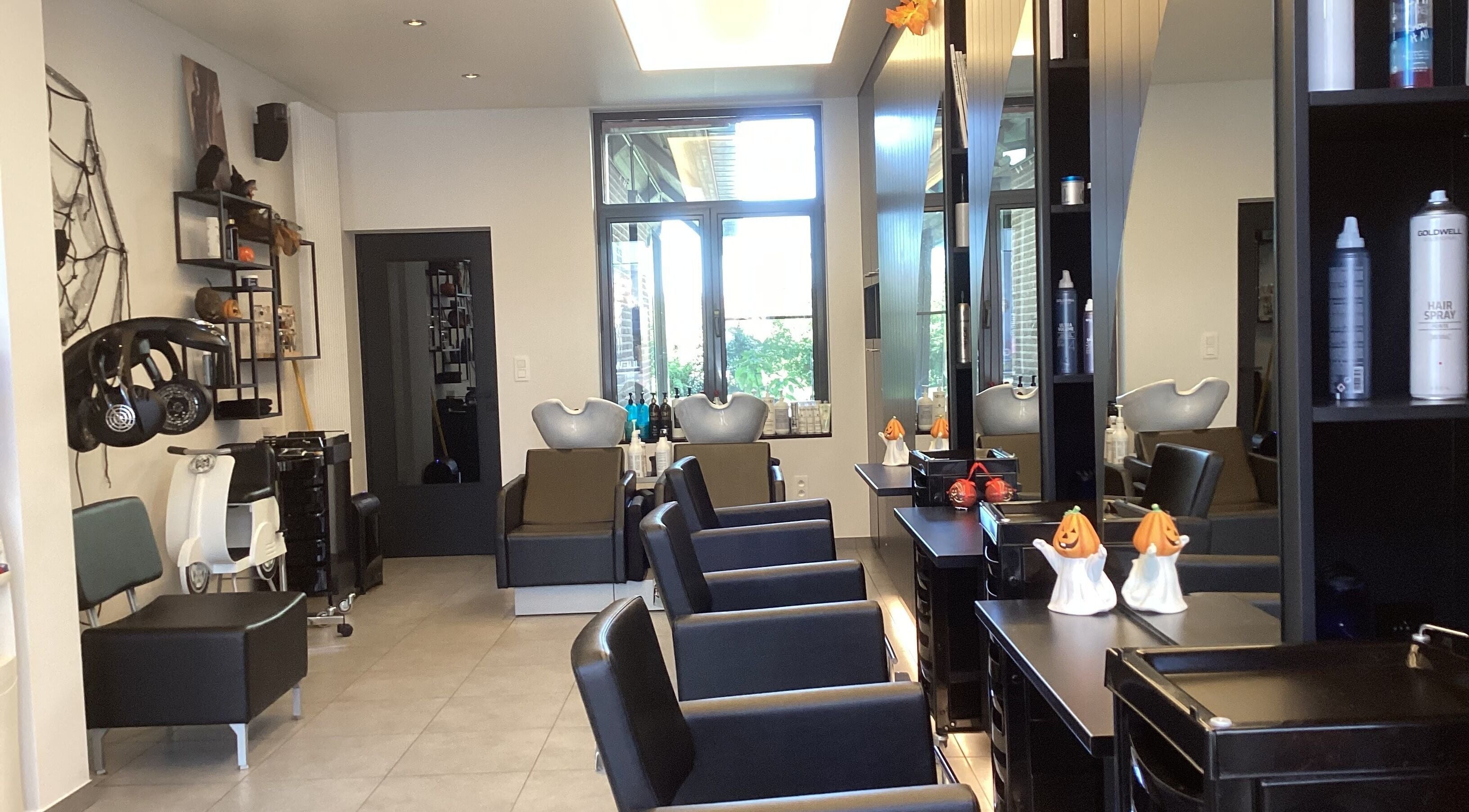 Interieur van Kapsalon Sigrid in Waregem, Vlaanderen, BE met moderne stoelopstelling.