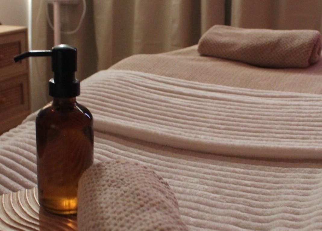 Salle de massage relaxante à Rituel Cocooning, Caen, Normandie, FR, avec serviettes et huile essentielle.